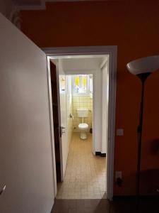un corridoio di un bagno con servizi igienici e porta di Charming Room in the heart of Locarno a Locarno