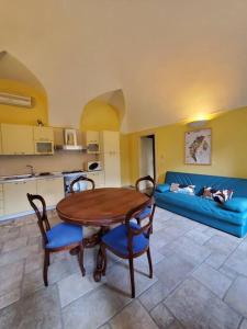 a living room with a table and a blue couch at Gallina Apartment in Bra