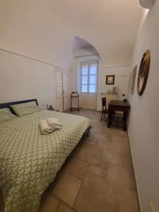 a bedroom with a bed and a table and a window at Gallina Apartment in Bra