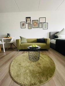 ein Wohnzimmer mit einem grünen Sofa und einem Tisch in der Unterkunft Modernes City-Appartement in Bielefeld