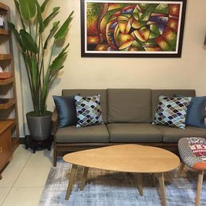 uma sala de estar com um sofá e uma mesa em The Redwoods Fairview Quezon City em Manila