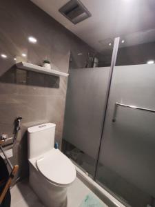 uma casa de banho com um WC e um chuveiro em The Redwoods Fairview Quezon City em Manila