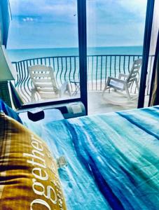 a bedroom with a bed and a view of the ocean at Ocean Front 53 Steps in Myrtle Beach