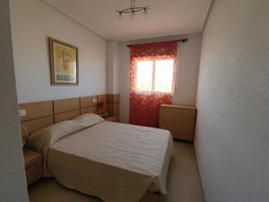 ein kleines Schlafzimmer mit einem Bett und einem Fenster in der Unterkunft Apartamento acogedor en Cabanes, Torre la Sal, Costamar I Marina d'Or in La Estación