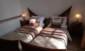 twee bedden in een kleine kamer met twee lampen bij Hotel Bristol in Tarnów
