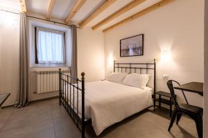 ein Schlafzimmer mit einem Bett, einem Tisch und einem Stuhl in der Unterkunft il Glicine B&B RISTORANTE in Cazzago San Martino