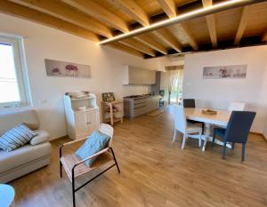 a living room with a table and chairs and a kitchen at Casa Zoe in Colico