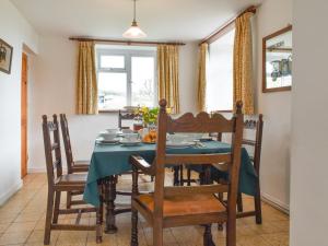 Garway的住宿－Keepers Cottage，一间配备有蓝色桌子和椅子的用餐室