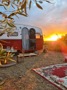 un camper parcheggiato di fronte al tramonto di SA MOLA GLAMPING EXPERIENCE Roulotte a Escolca