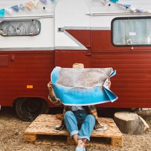 a person sitting on a chair in front of an rv at SA MOLA GLAMPING EXPERIENCE Roulotte in Escolca