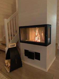 ein Kamin in einem Wohnzimmer mit einem brennenden Feuer in der Unterkunft Villa Iiris - Peaceful Lapland Villa Surrounded by Nature in Äkäslompolo