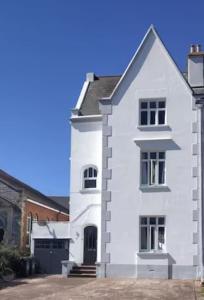 a white house with a black door at Huge 5 bed Grade II listed home in heart of town in Exmouth