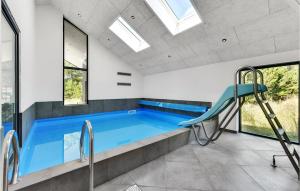een zwembad in een huis met ramen bij Nice Home In Blvand With Kitchen in Blåvand