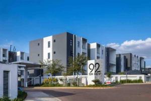 un grand bâtiment blanc avec une enseigne devant dans l'établissement 1 Harriet Place - Beautiful Self Catering 2 bedroom unit next to Carlswald Lifestyle Shopping Centre with free WiFi, Onsite Restaurant & Swimming Pool- Perfect for a small family in Midrand Carlswald, à Midrand