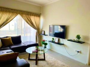 un salon avec un canapé et une télévision dans l'établissement 1 Harriet Place - Beautiful Self Catering 2 bedroom unit next to Carlswald Lifestyle Shopping Centre with free WiFi, Onsite Restaurant & Swimming Pool- Perfect for a small family in Midrand Carlswald, à Midrand