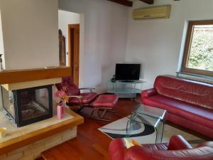 a living room with a red couch and a fireplace at Villa Fiumana in Rijeka