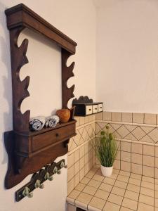 a tiled bathroom with a mirror and a plant at House among olive trees with a sea view 3 in Ankaran