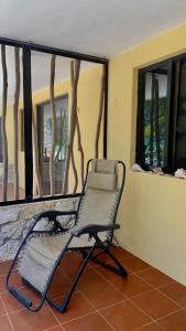 a rocking chair in a room with a window at Beachfront apartment with swimming pool. One bedroom in Celestún