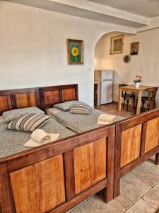 a large wooden bed in a room with a kitchen at House among olive trees with a sea view 3 in Ankaran