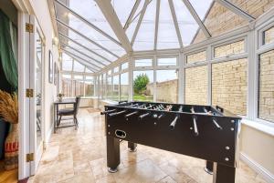 a pool table in a room with a glass ceiling at Pheasant House by Apricity Property - 5 bedrooms, 2 Bathrooms and a WC, Foosball table, free parking, Garden, Workspace in Cirencester