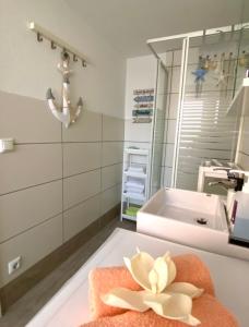 a bathroom with a sink and a flower on a towel at Apartment Glesch in Bergheim