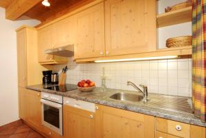 una cocina con armarios de madera y fregadero en Kaiser-Franz-Josef Hütten ZILF1002, en Hochfügen