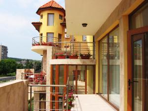 un edificio con un balcón con flores. en Hotel Queen en Aydemir