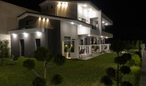 a white house with lights on a yard at night at Perla Inn in Stavros