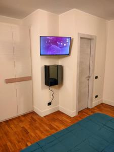 um quarto com uma televisão de ecrã plano na parede em Locanda La Lucciola em Portovenere
