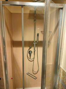 um chuveiro numa casa de banho com uma porta de vidro em Locanda La Lucciola em Portovenere