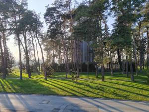 un parque con árboles y césped y un edificio en Apartment Una en Bjelovar