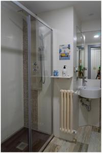 a bathroom with a glass shower and a sink at Luengo House in León