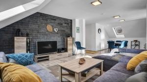 a living room with a couch and a tv at Apartmány Čtyřlístek in Loučná pod Klínovcem