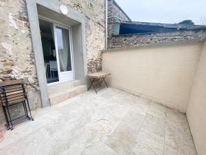 une terrasse avec une porte et un banc à côté d'un bâtiment dans l'établissement Le Cocon de Saint Arnoult, à Saint-Arnoult-en-Yvelines