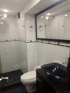 y baño con aseo, lavabo y espejo. en Apartamento centro. Espectaculares vistas, en Bogotá