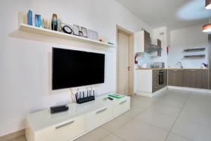 ein großes weißes Wohnzimmer mit einem Flachbild-TV in der Unterkunft Depiro Point Sliema Luxury Apartment in Sliema