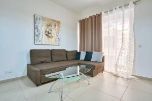 ein Wohnzimmer mit einem Sofa und einem Glastisch in der Unterkunft Depiro Point Sliema Luxury Apartment in Sliema