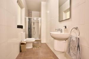 a white bathroom with a toilet and a sink at Depiro Point Sliema Luxury Apartment in Sliema