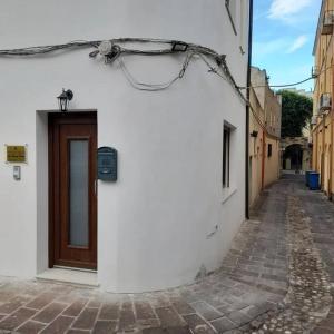 a white building with a door on a street at Casa al Corso Sant'Antioco (SU) in SantʼAntìoco
