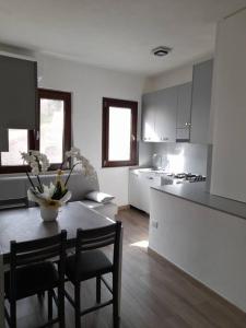 a kitchen with a table and chairs and a kitchen with a counter at Casa al Corso Sant'Antioco (SU) in SantʼAntìoco