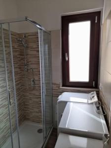 a bathroom with a shower and a glass shower stall at Casa al Corso Sant'Antioco (SU) in SantʼAntìoco
