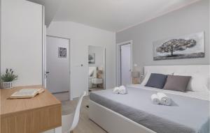 - une chambre blanche avec un lit et un bureau dans l'établissement 3 Bedroom Amazing Home In Veli Jezenj, à Veli Ježenj