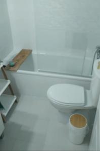 a bathroom with a white toilet and a wooden counter at Zaharaiso luz in Zahara de los Atunes