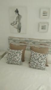 two pillows on a bed with a picture on the wall at Zaharaiso luz in Zahara de los Atunes