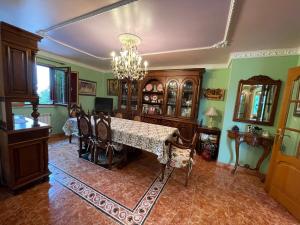 uma sala de jantar com uma mesa e cadeiras e um lustre em Impresionante casa con parcela en la naturaleza em La Coruña