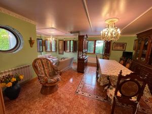 ein Wohnzimmer mit einem Kronleuchter und einem Tisch in der Unterkunft Impresionante casa con parcela en la naturaleza in A Coruña