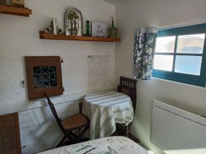 a room with two chairs and a table and a window at L'atelier-chambrette dans le jardin avec salle de bains, sans cuisine in Trôo