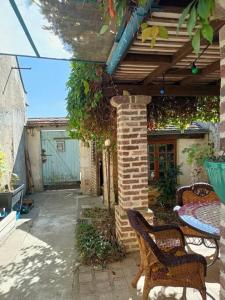 a patio with a table and chairs and a building at L'atelier-chambrette dans le jardin avec salle de bains, sans cuisine in Trôo +4 photos