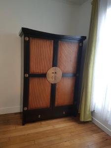 een grote houten kast met een ventilator in een kamer bij Paris Esprit loft, lumineux in Aubervilliers