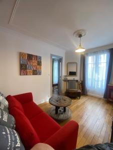 - un salon avec un canapé rouge et une table dans l'établissement Paris Esprit loft, lumineux, à Aubervilliers